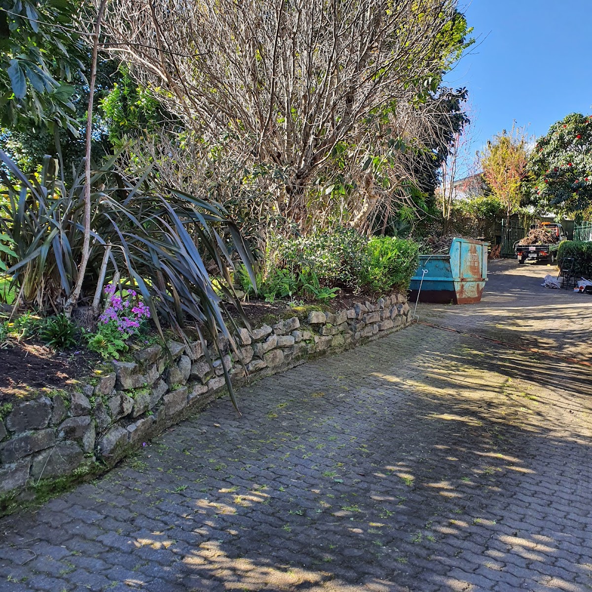 Dry-stone retaining wall and cottage planting along a driveway